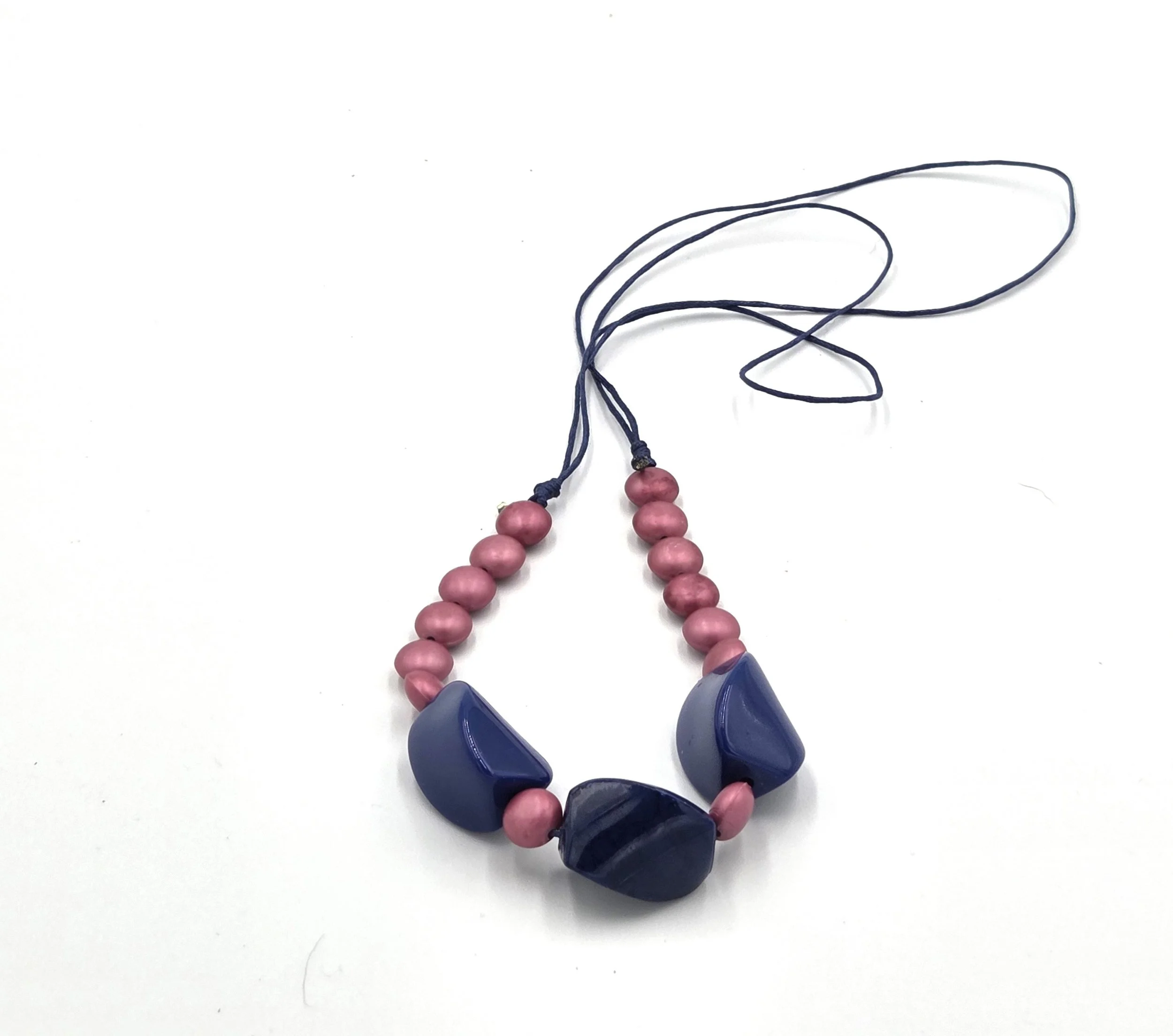 Navy blue twisted bead necklace with matte pink accents on adjustable hemp cord.