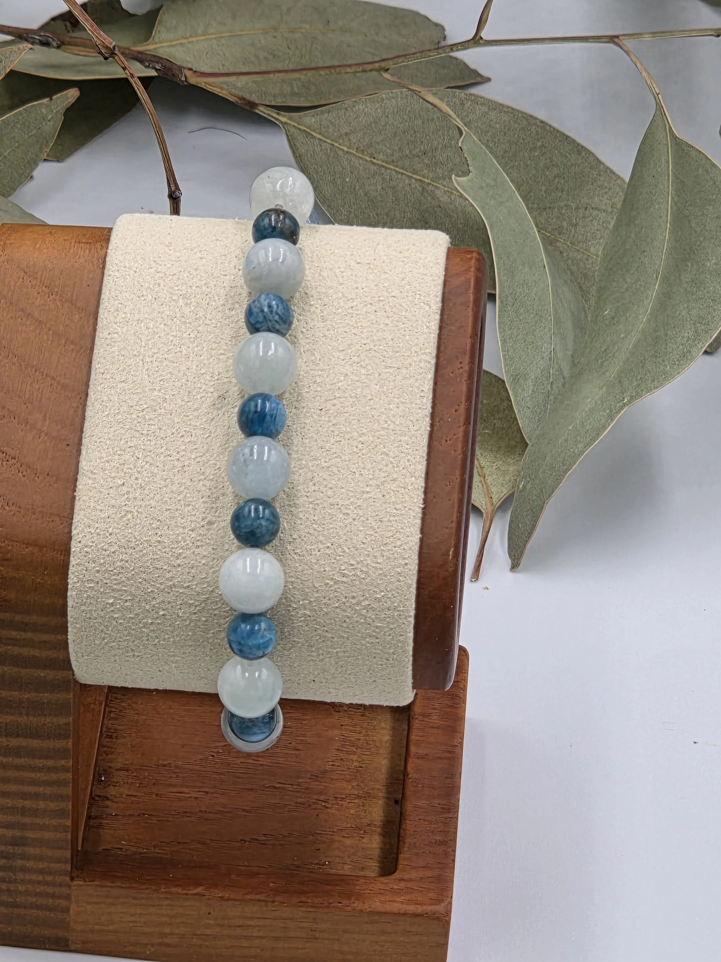 Alternating light blue-green Aquamarine beads and dark blue Apatite beads on an elastic gemstone bracelet.