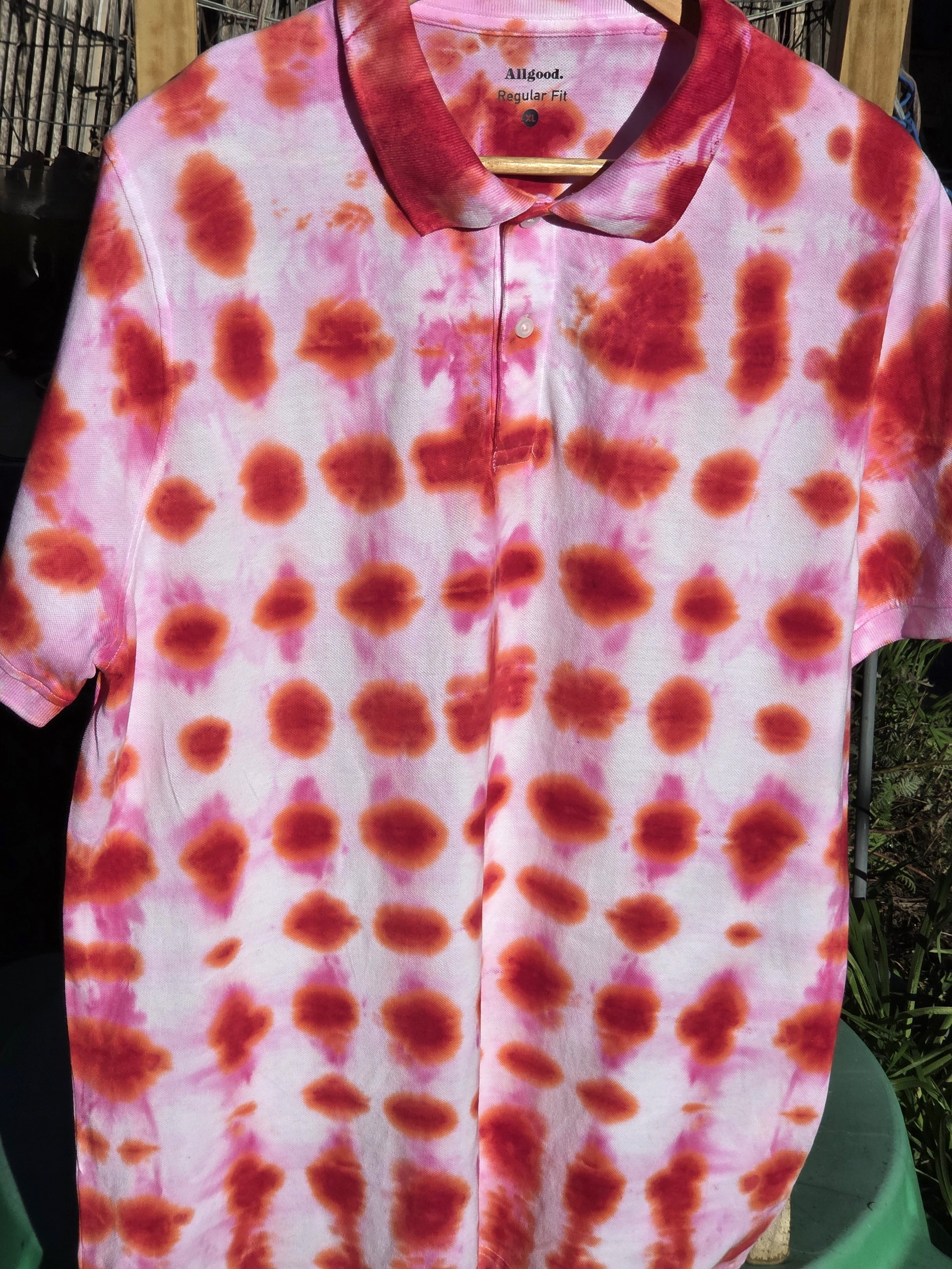 An adult size XL cotton polo shirt featuring a red tie-dye waffle weave pattern with lighter red bleeding into white negative space.