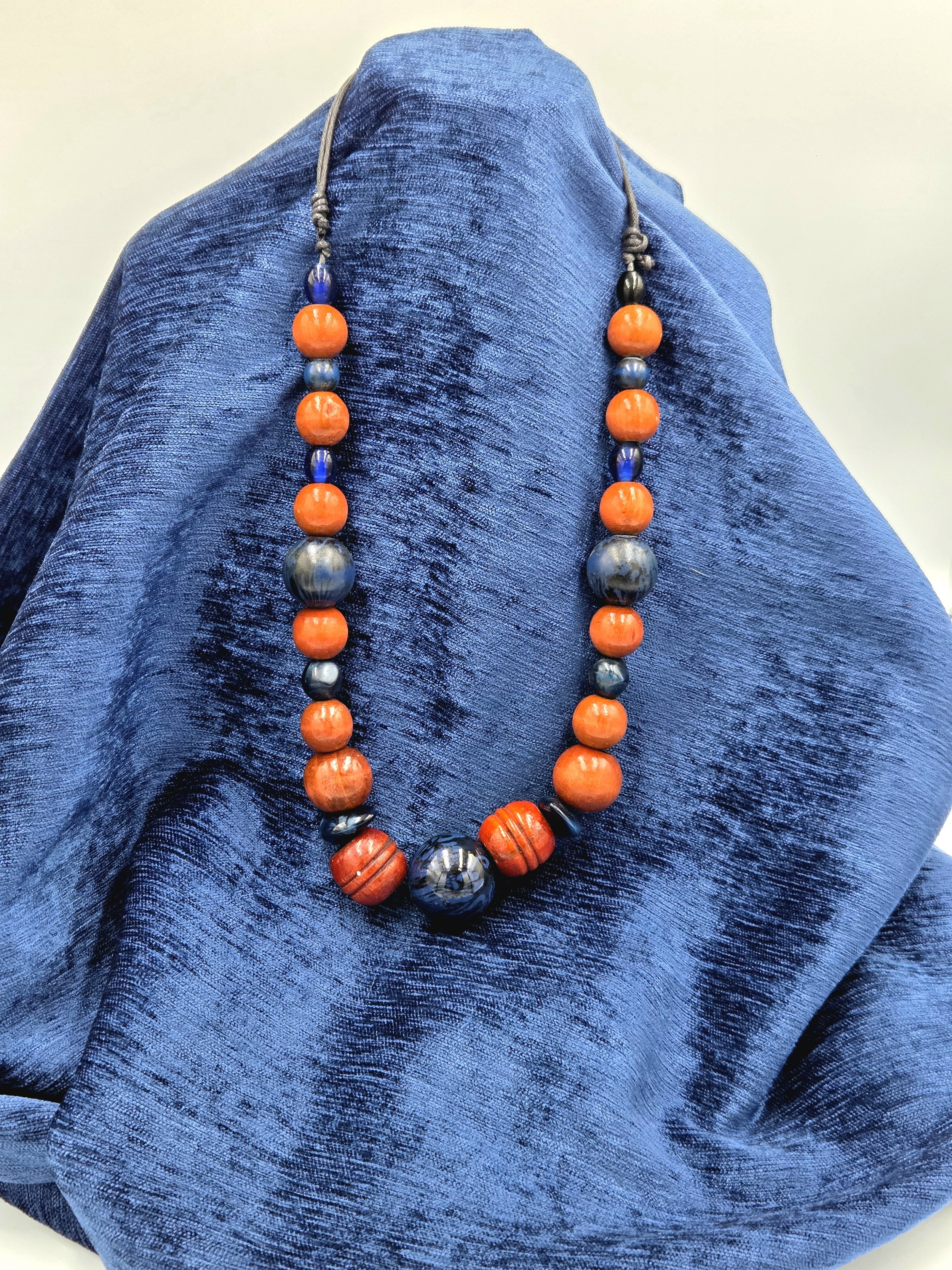 OOAK wearable sculpture featuring deep blue focal beads and large carved brown wood beads.