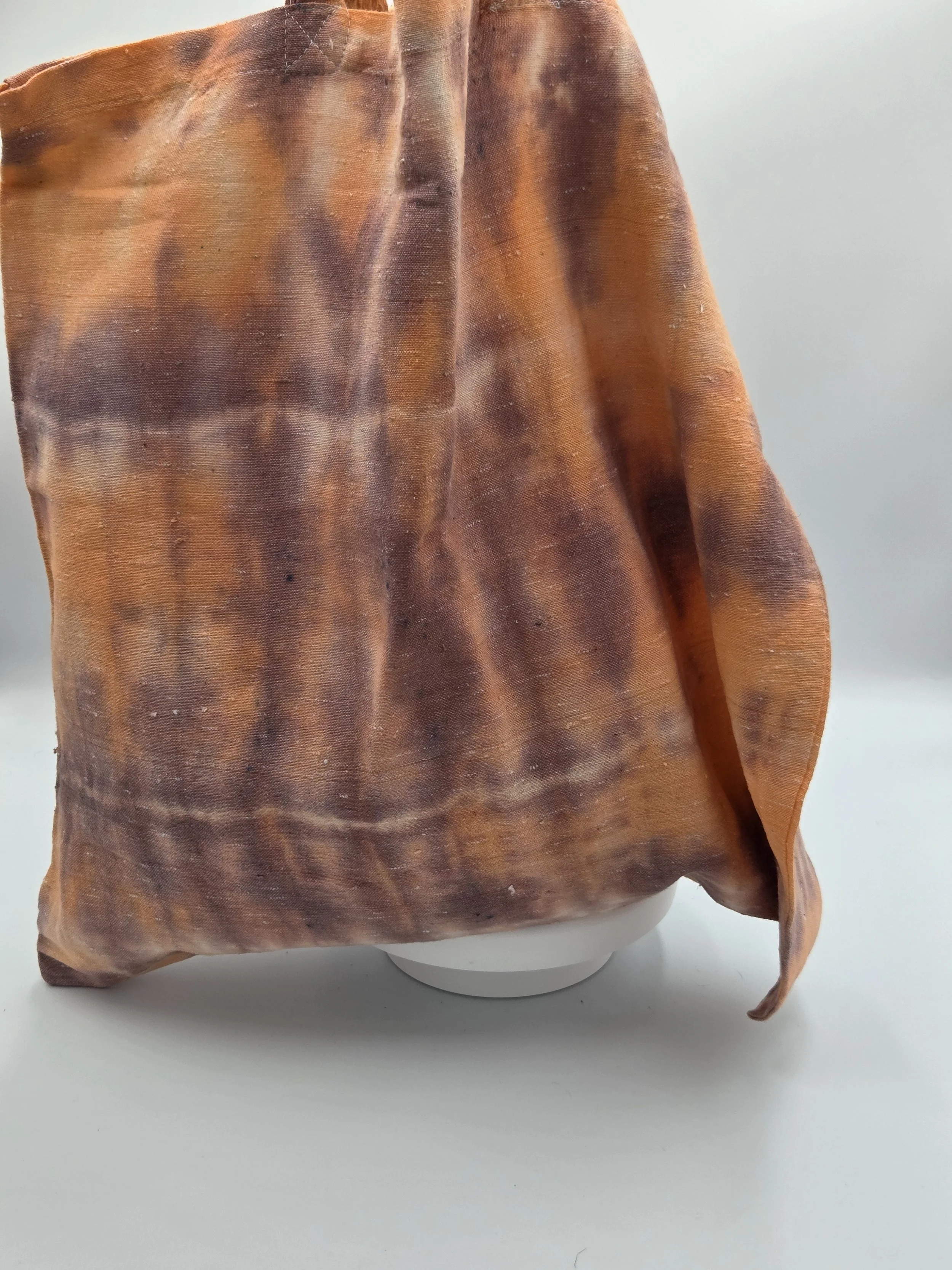 Hand-dyed calico cotton tote bag with a faded horizontal rainfall pattern in light brown and pastel orange. OOAK textile art by Livity Studio.
