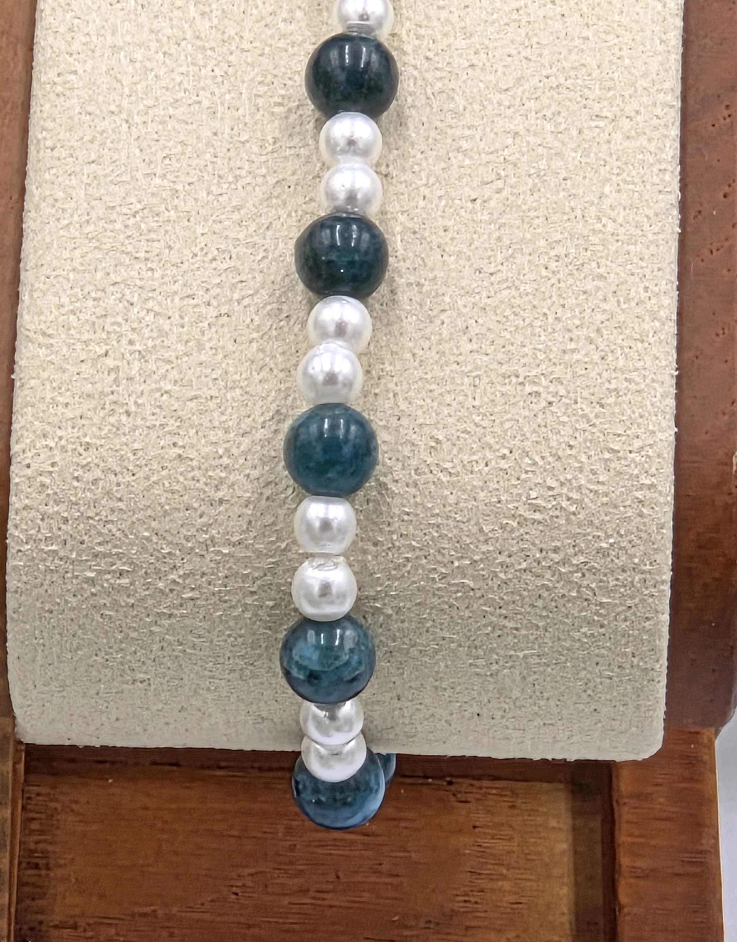 Deep blue Apatite beads alternating with small glossy white glass pearls on a delicate elastic bracelet.