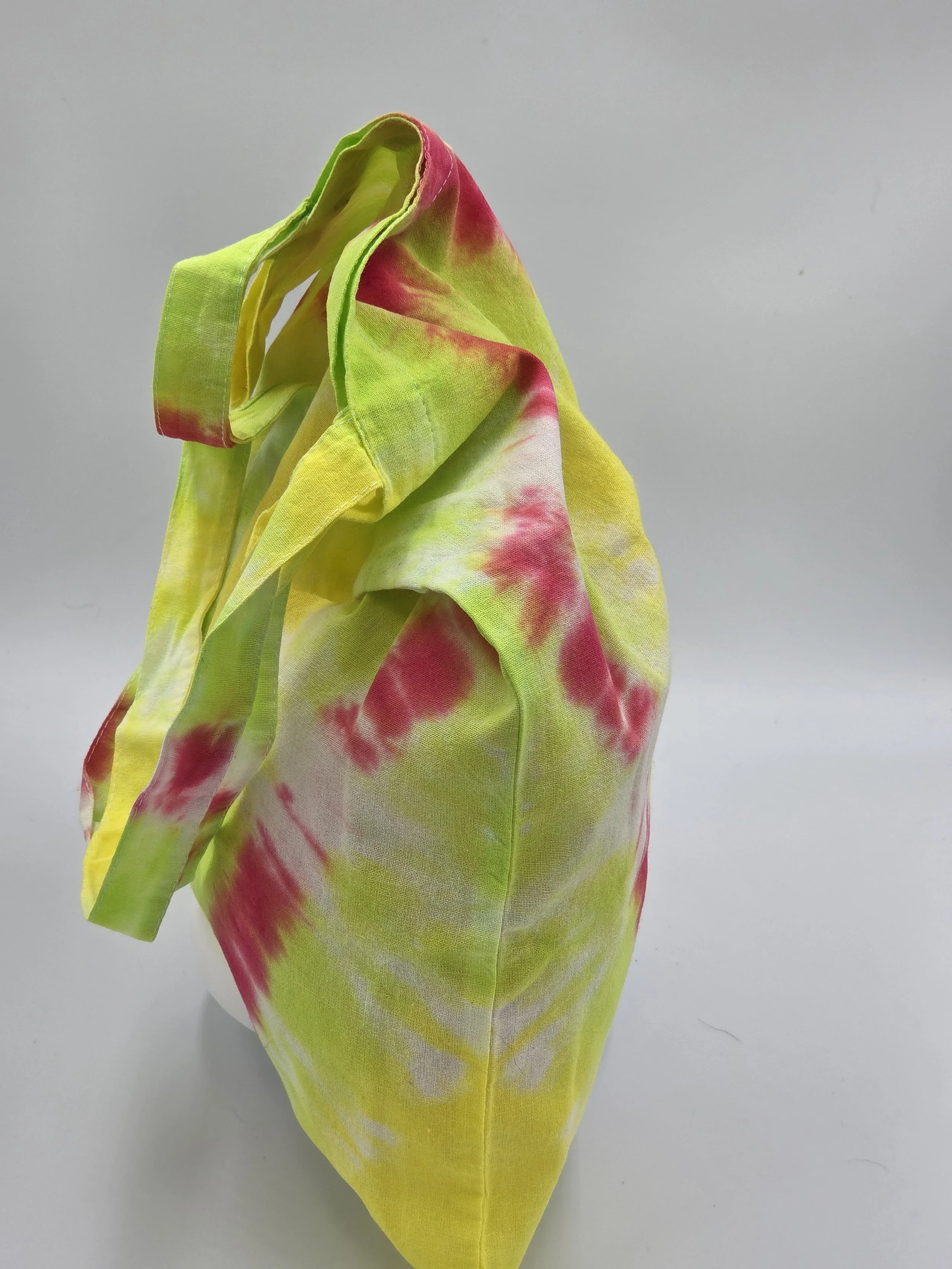 Hand-dyed cotton tote bag with a fuchsia diamond center on a lime and yellow background. OOAK textile art by Livity Studio.