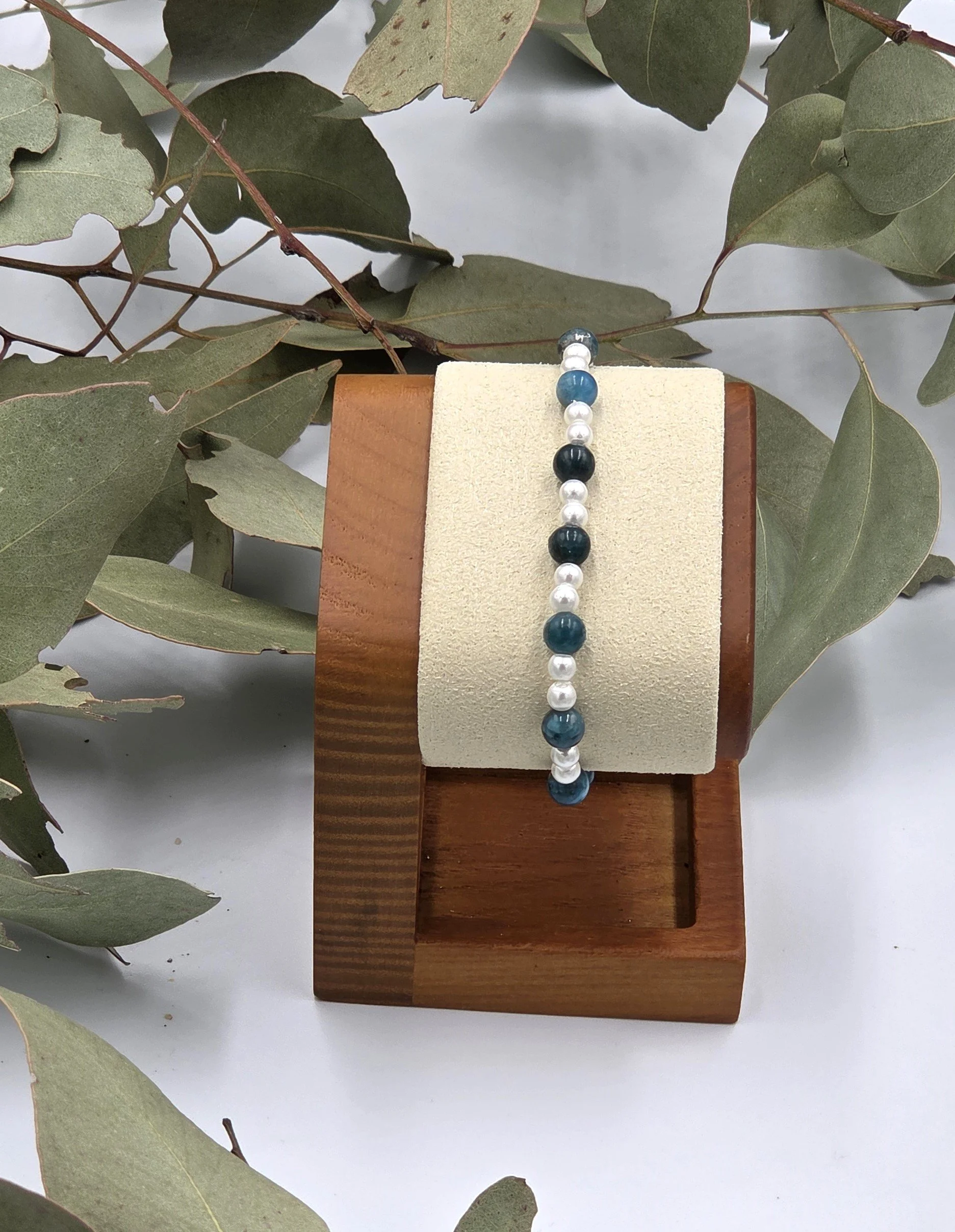 Deep blue Apatite beads alternating with small glossy white glass pearls on a delicate elastic bracelet.