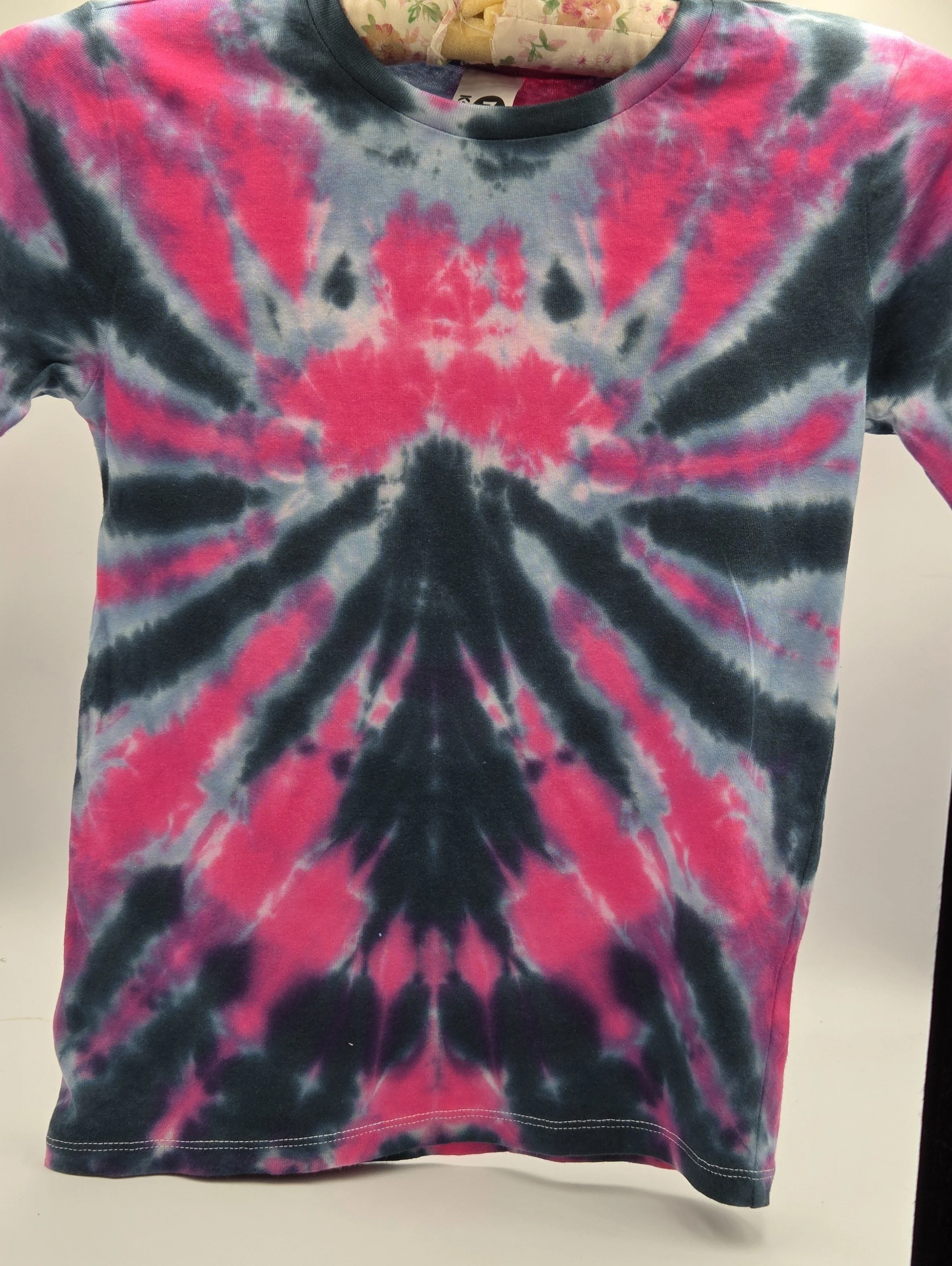 A child size 7 cotton t-shirt featuring a dramatic fuchsia and black spider tie-dye pattern with soft grey accents.