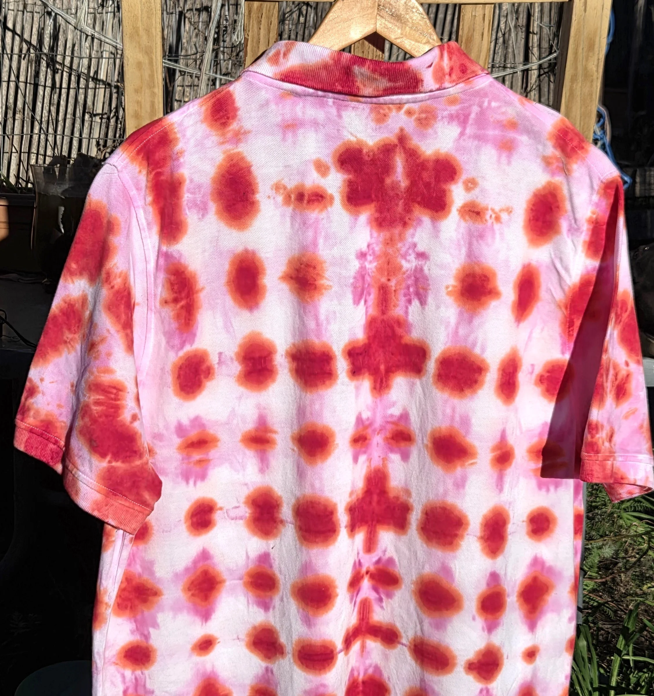 An adult size XL cotton polo shirt featuring a red tie-dye waffle weave pattern with lighter red bleeding into white negative space.