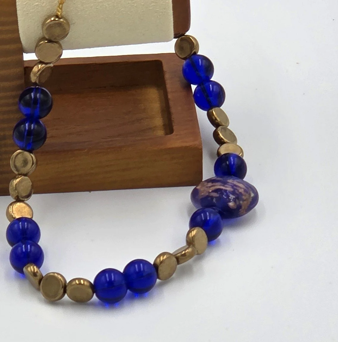 Dark blue and gold choker necklace with a large gold-foil glass bead