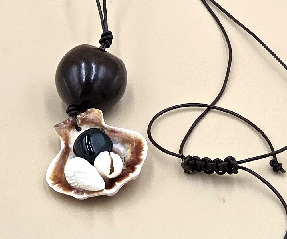 Australian handmade necklace with clam shell collage and seed pod on leather cord.