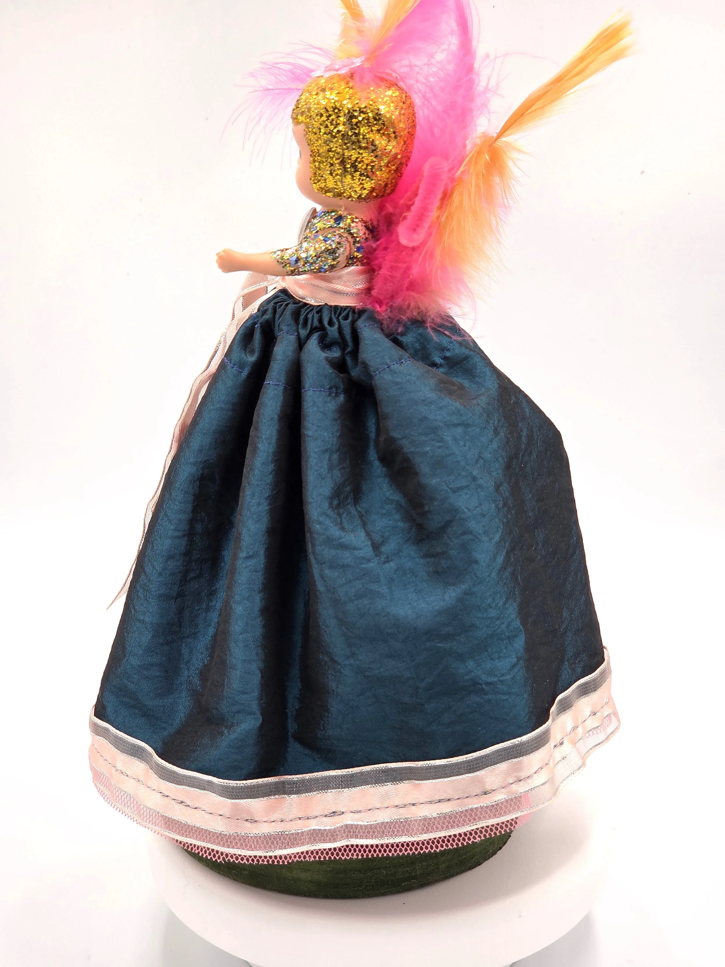 side view Garden Sprite doll in evergreen taffeta with pink ribbon and feathers.