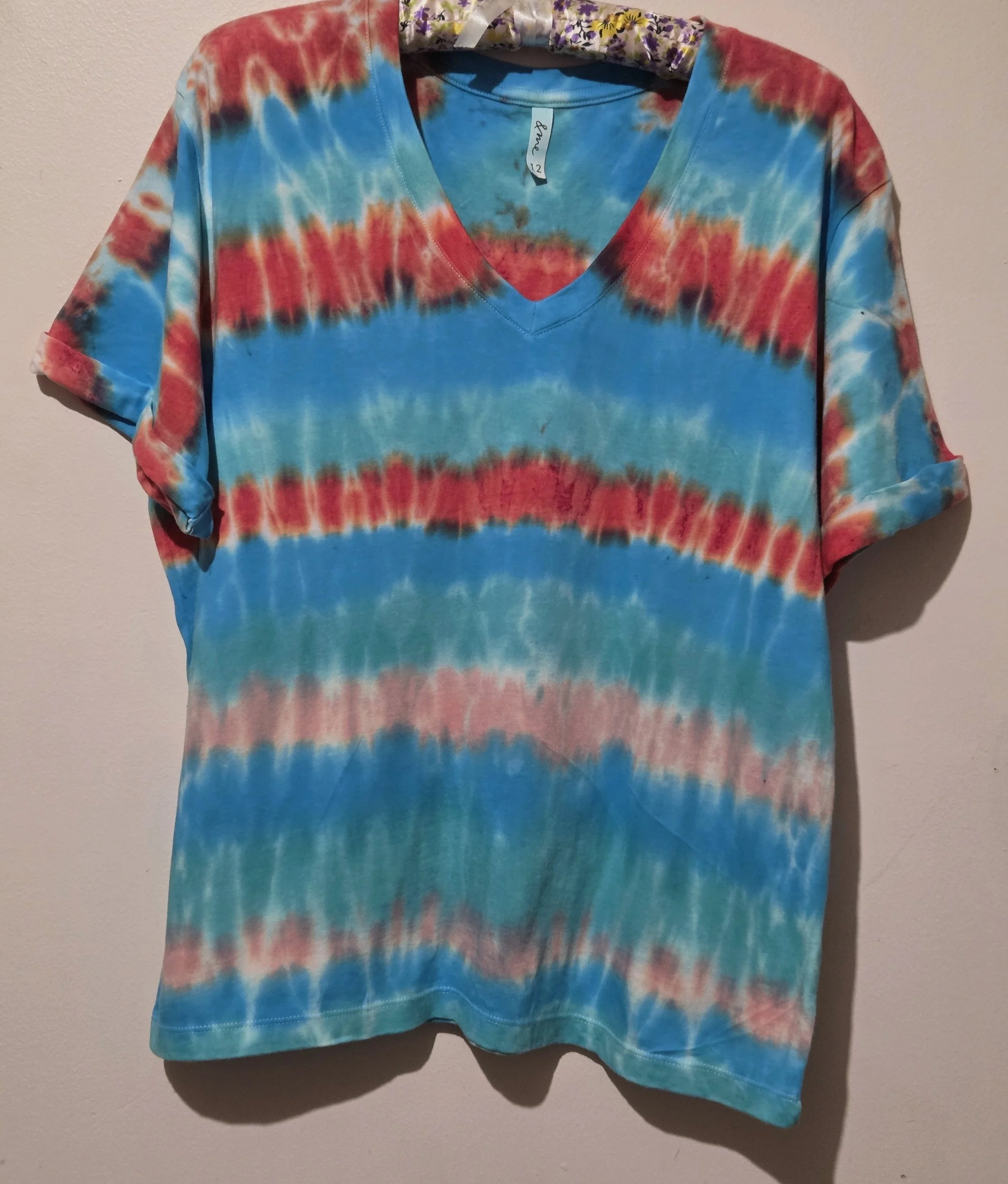 An adult size 12 women's V-neck cotton t-shirt with horizontal tie-dye stripes in coral, pink, turquoise, and Aegean green