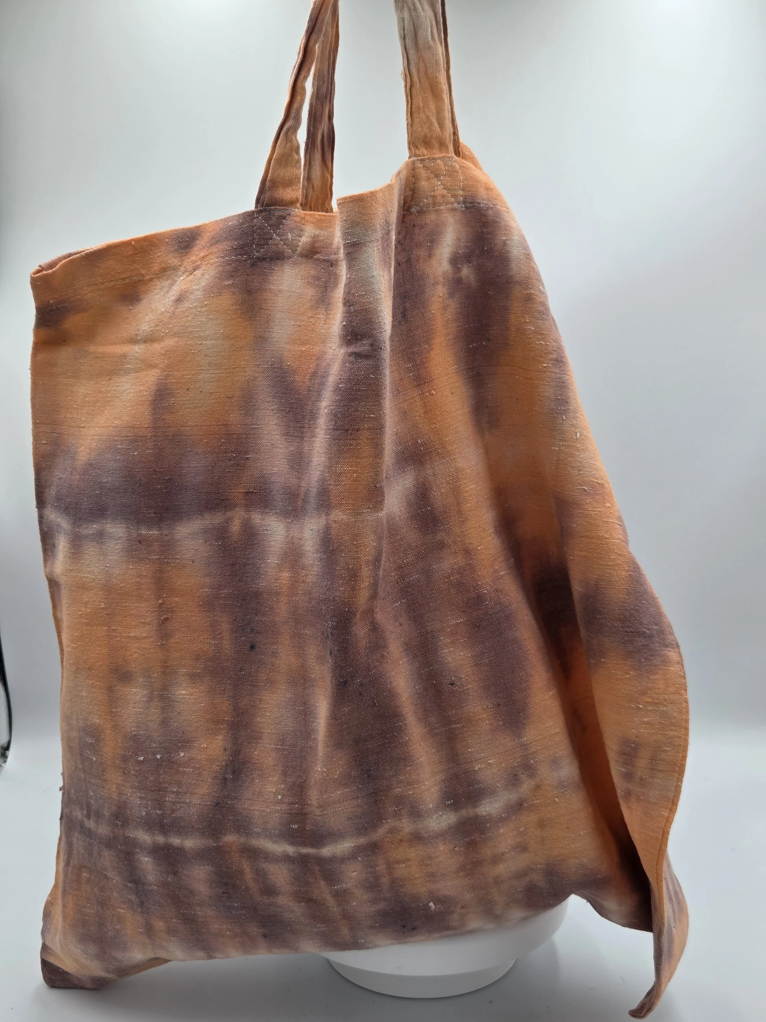 Hand-dyed calico cotton tote bag with a faded horizontal rainfall pattern in light brown and pastel orange. OOAK textile art by Livity Studio.