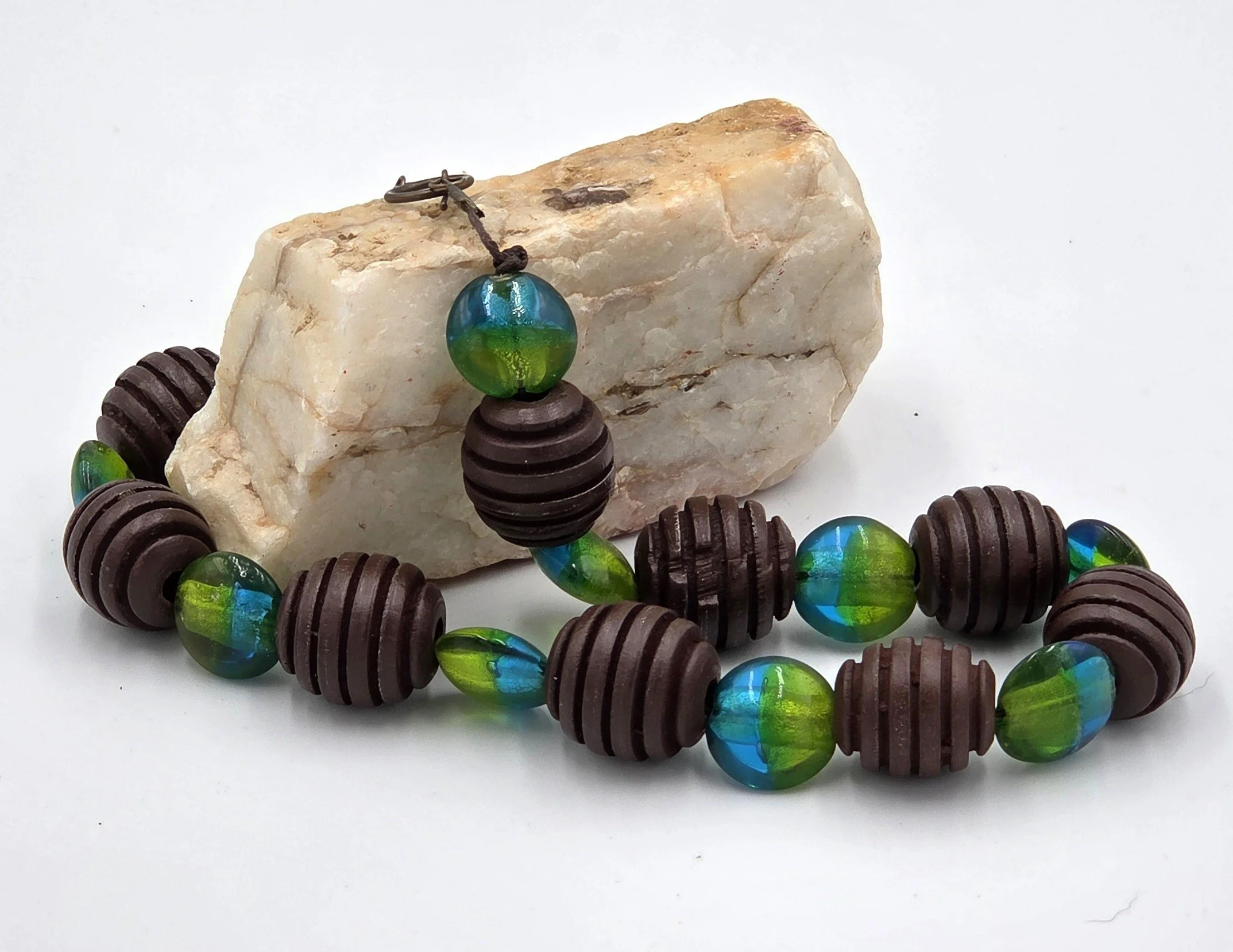 Choker necklace with large ribbed brown wood beads and blue-green foil glass beads.