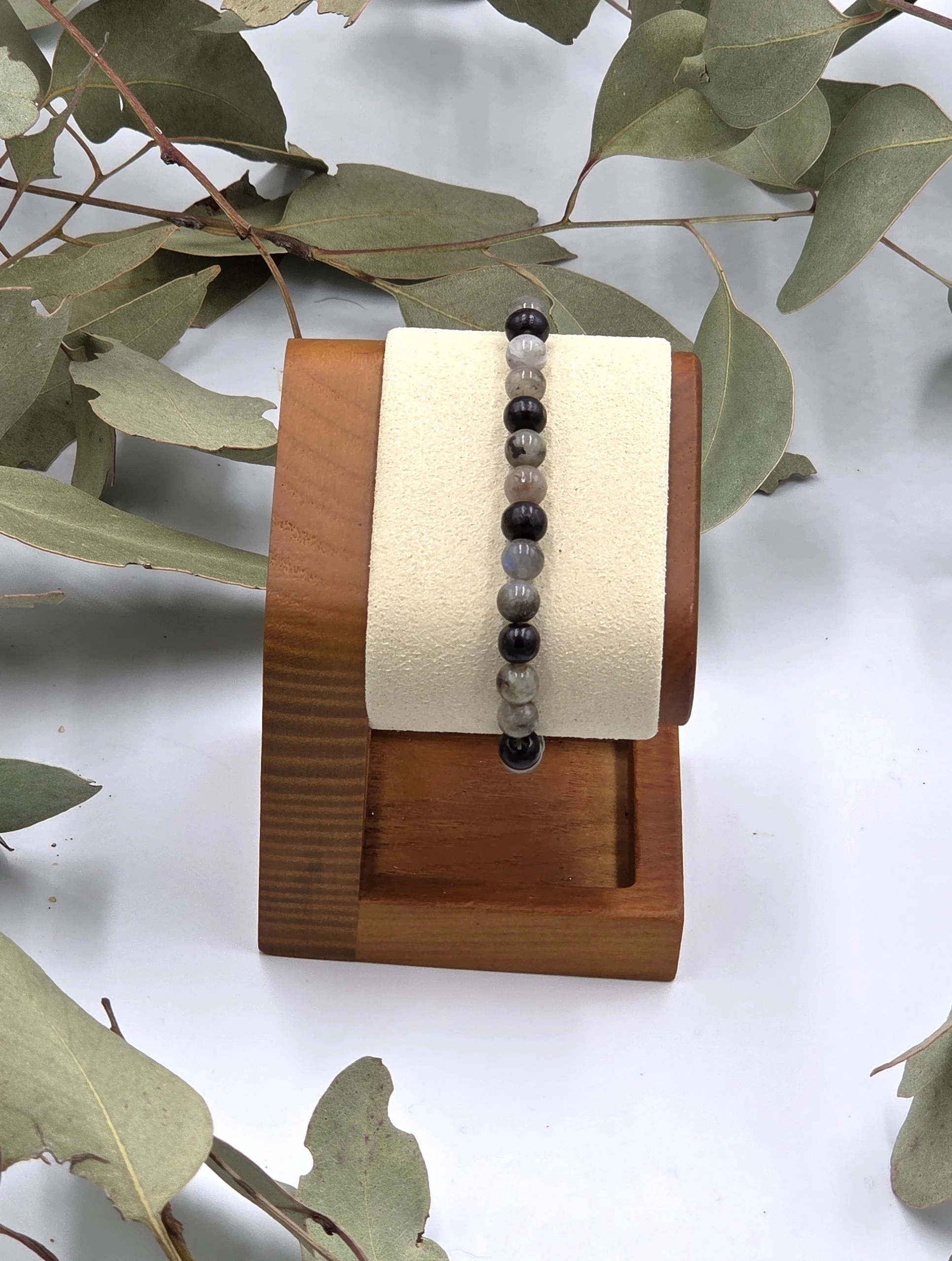Grey Labradorite beads alternating in pairs with single black wood beads on an elastic bracelet.