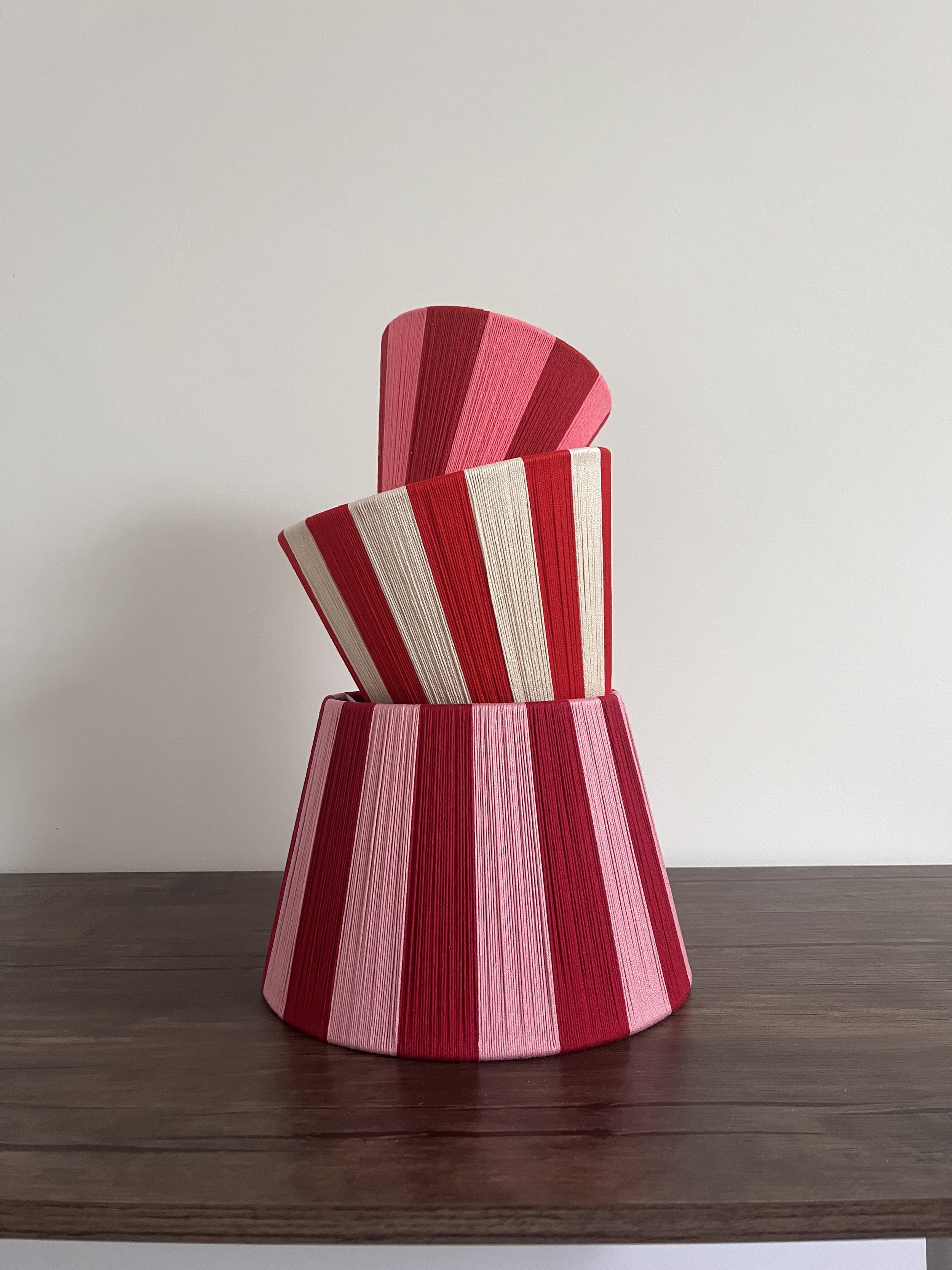 Three Red String Lampshades of different sizes all stacked on top of each other to create a lampshade tower