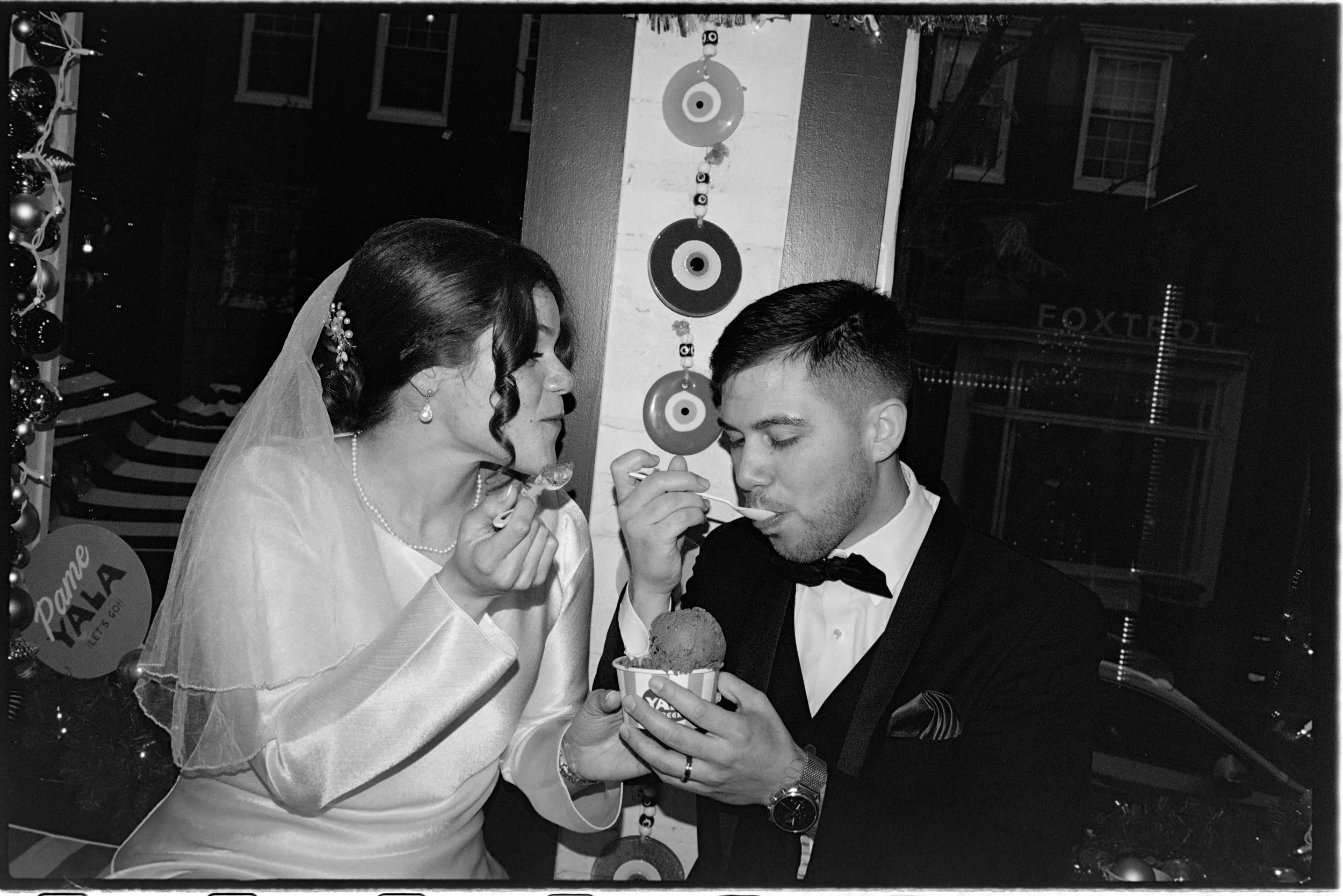 Honest, non-posed wedding moments captured on analog film of a couple eating ice cream after saying "I do".