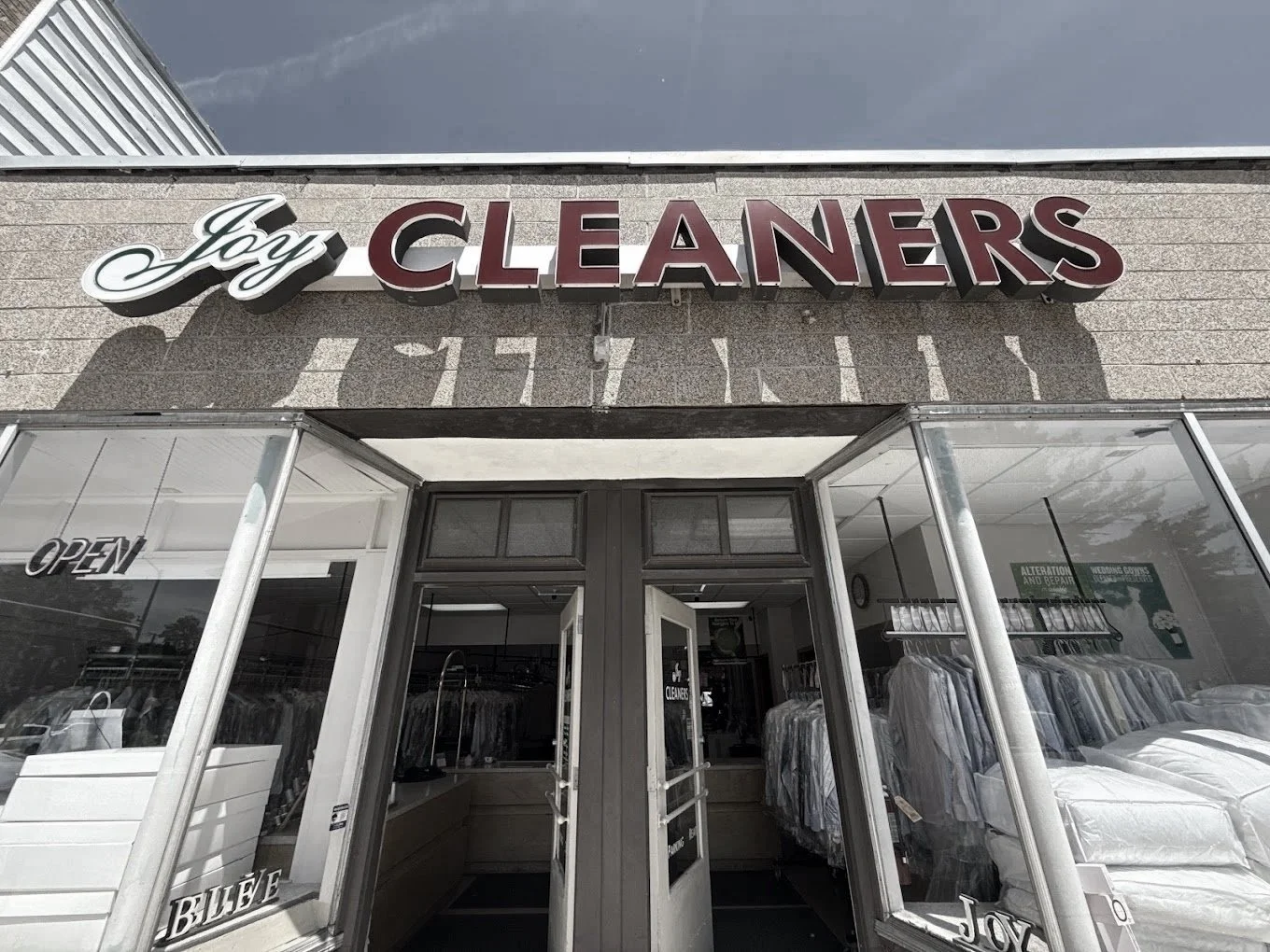 Joy Cleaners storefront entrance offering dry cleaning, laundry, and alteration services in Milwaukee, Wisconsin.