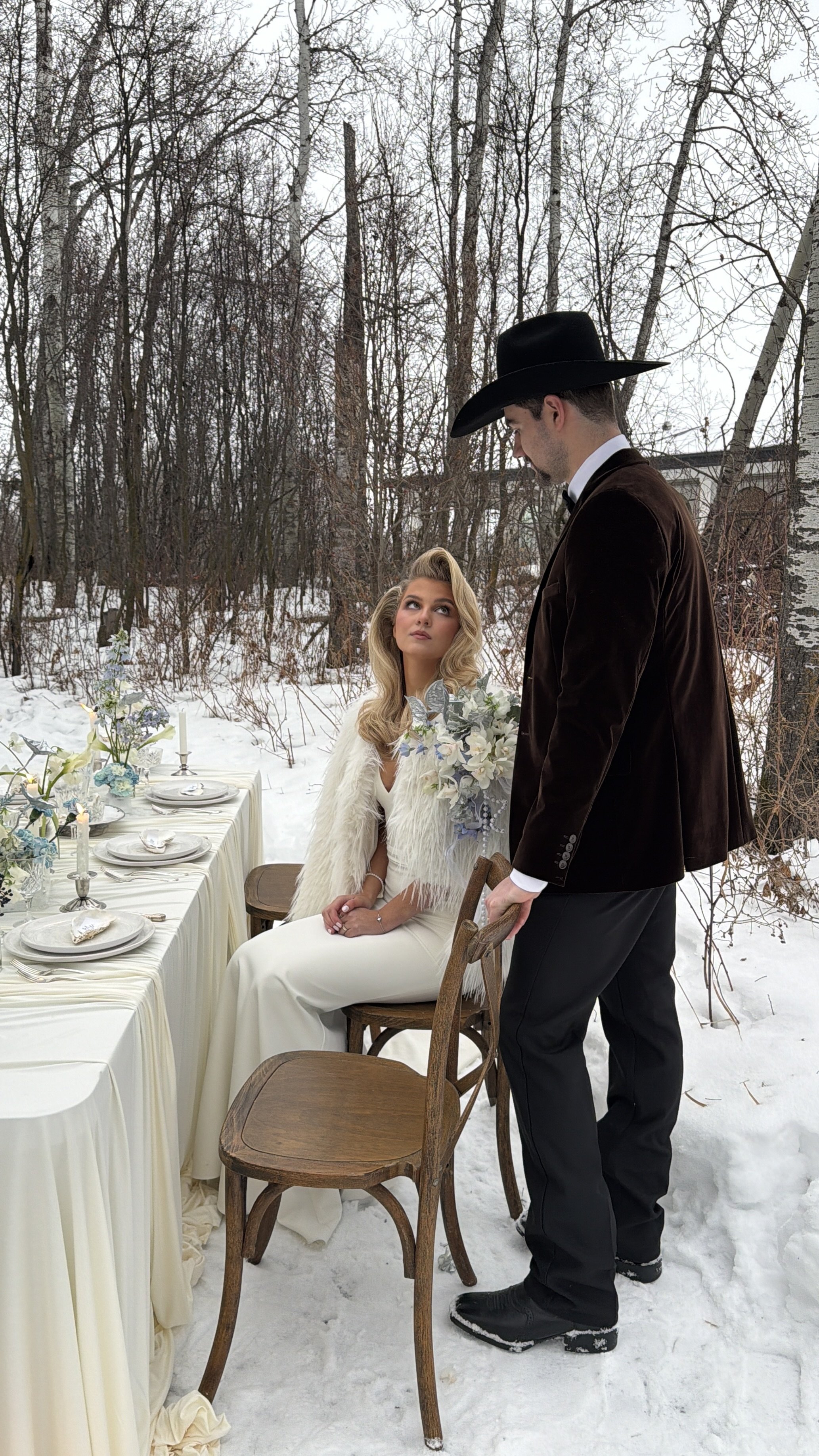 Bride and Groom at Sparrow Lane Events, featuring ivory and blue winter wedding decor, pearls, and snowy tablescape accents.