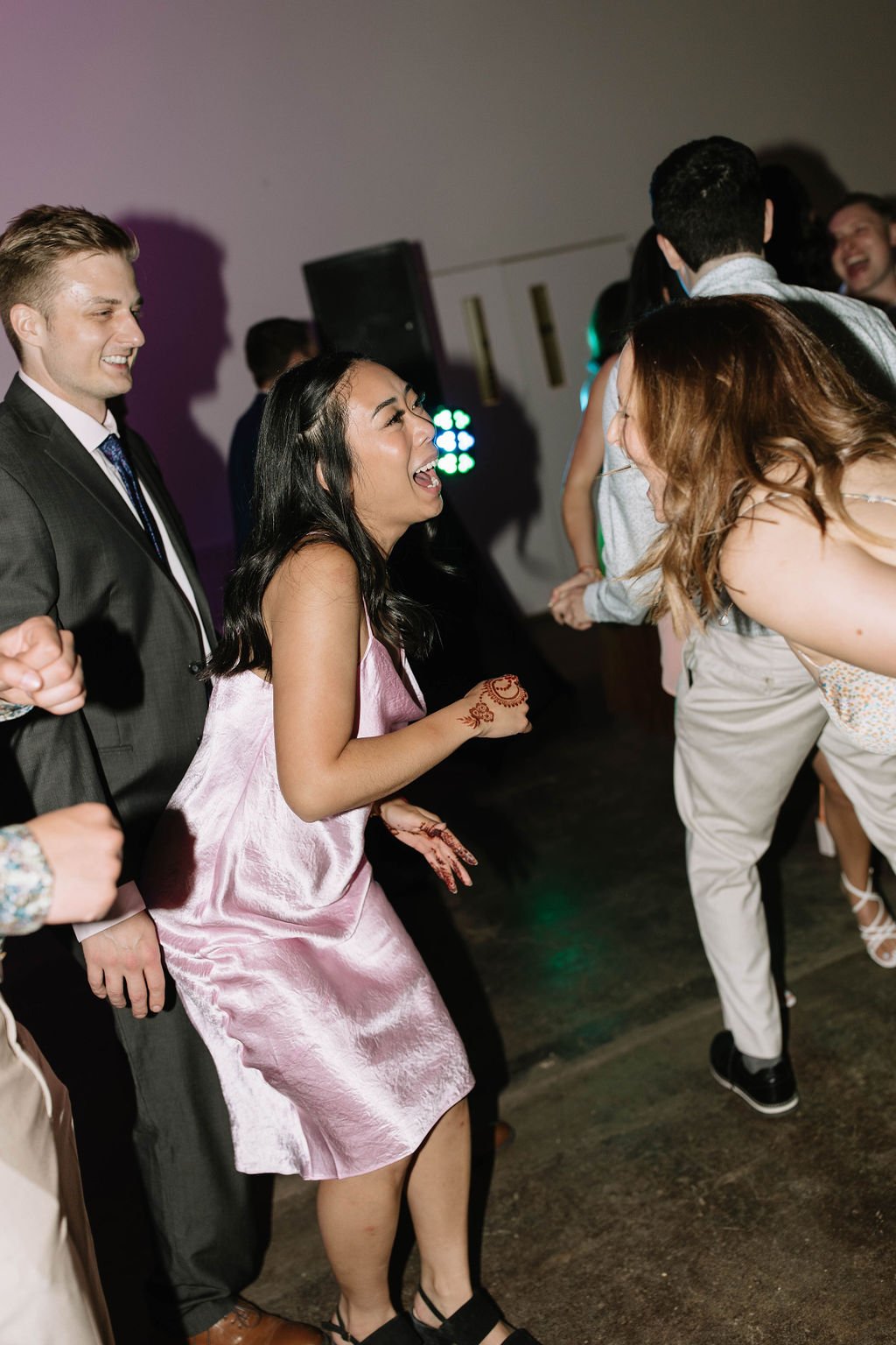 Fun photograph taken by Edmonton photographer of guests dancing at the reception