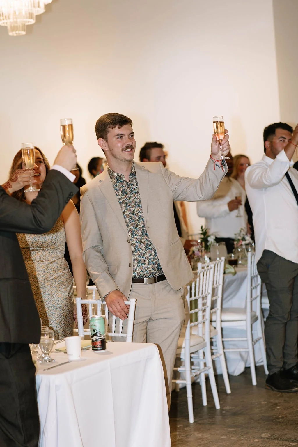 Authentic moment of guest cheers to the bride and groom at their wedding reception