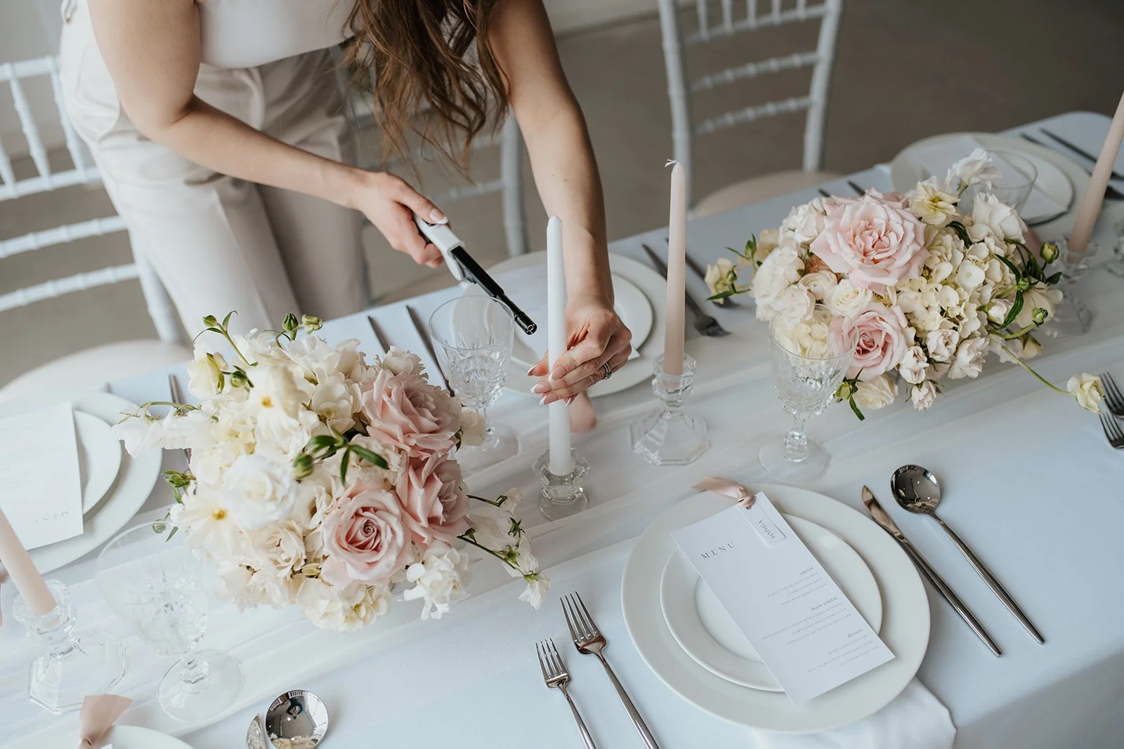 Image of wedding planner lighting a tablescape candle