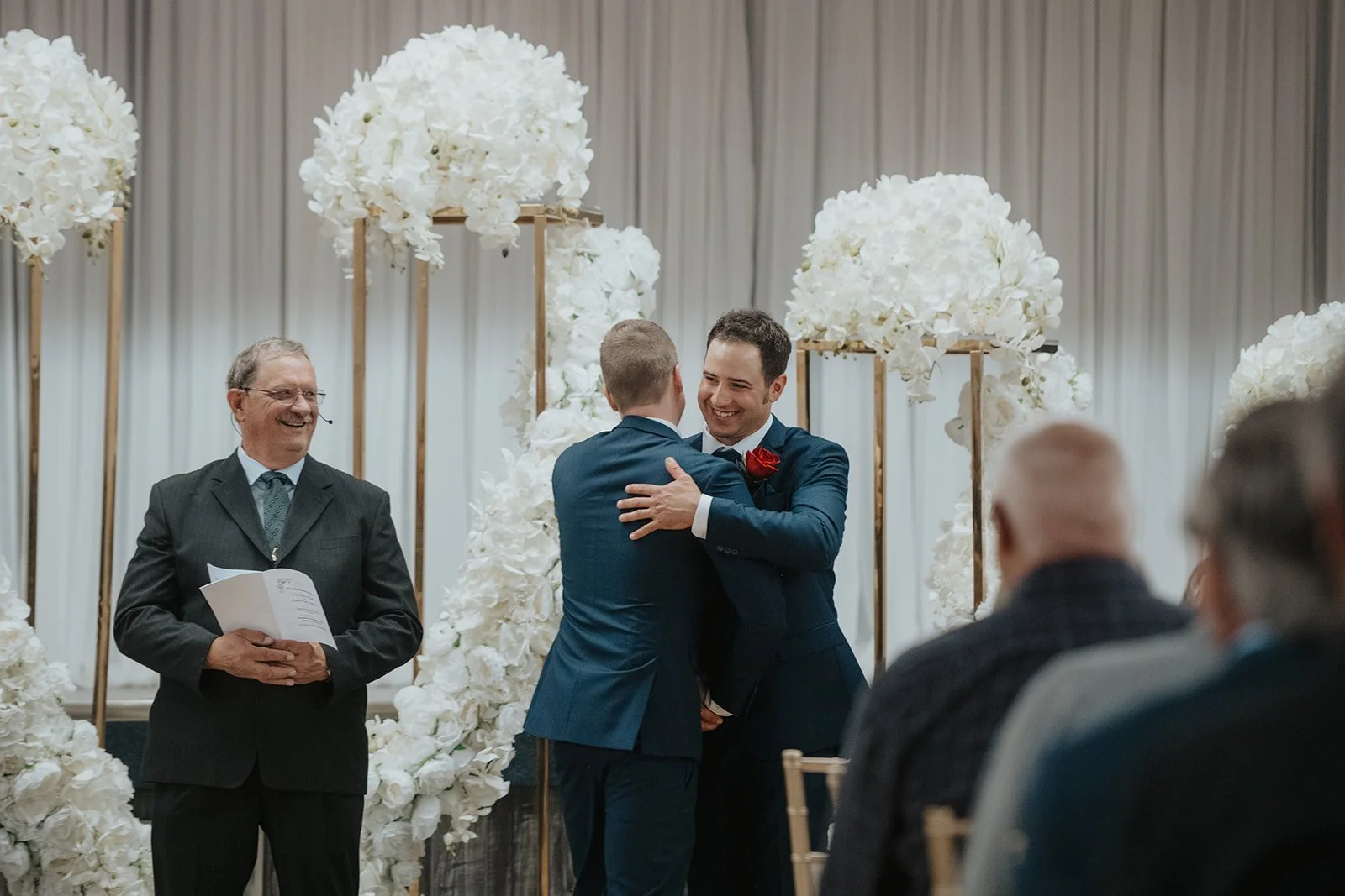 Image of Groom and his groomsmen hugging each other in front of alter at Alberta wedding