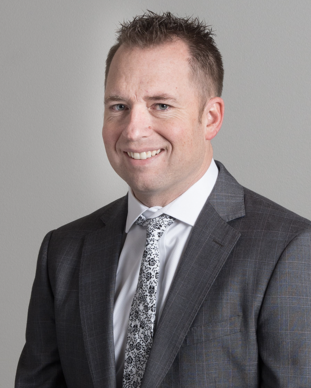 Person holding a football indoors wearing a suit