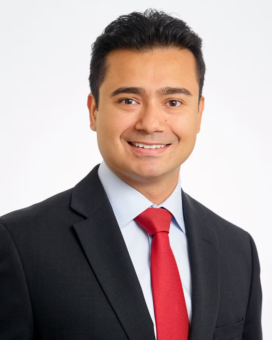 Person holding a football indoors wearing a suit