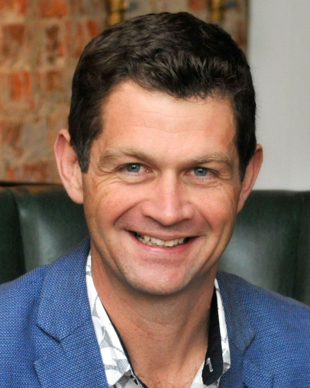 Person in green long-sleeve shirt and gray leggings standing in desert landscape with mountains in the background.