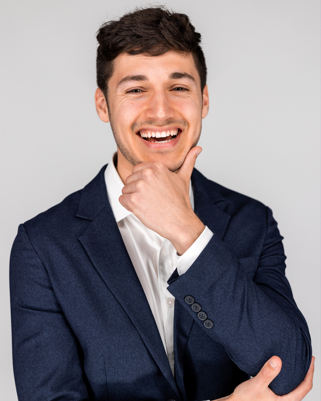 Person holding a football indoors wearing a suit