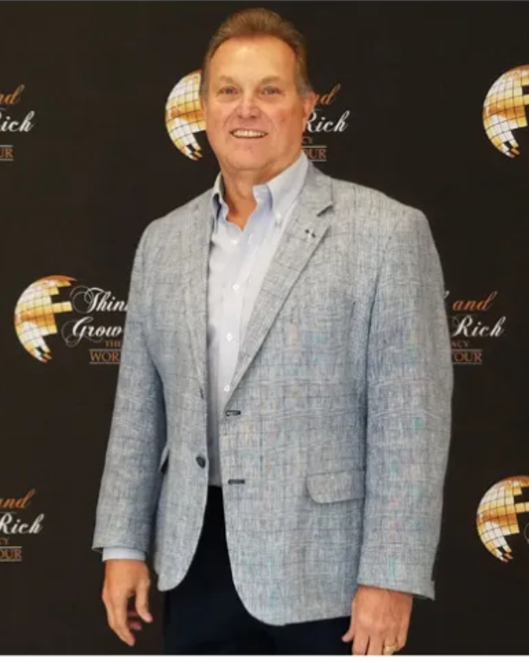 Person holding a football indoors wearing a suit