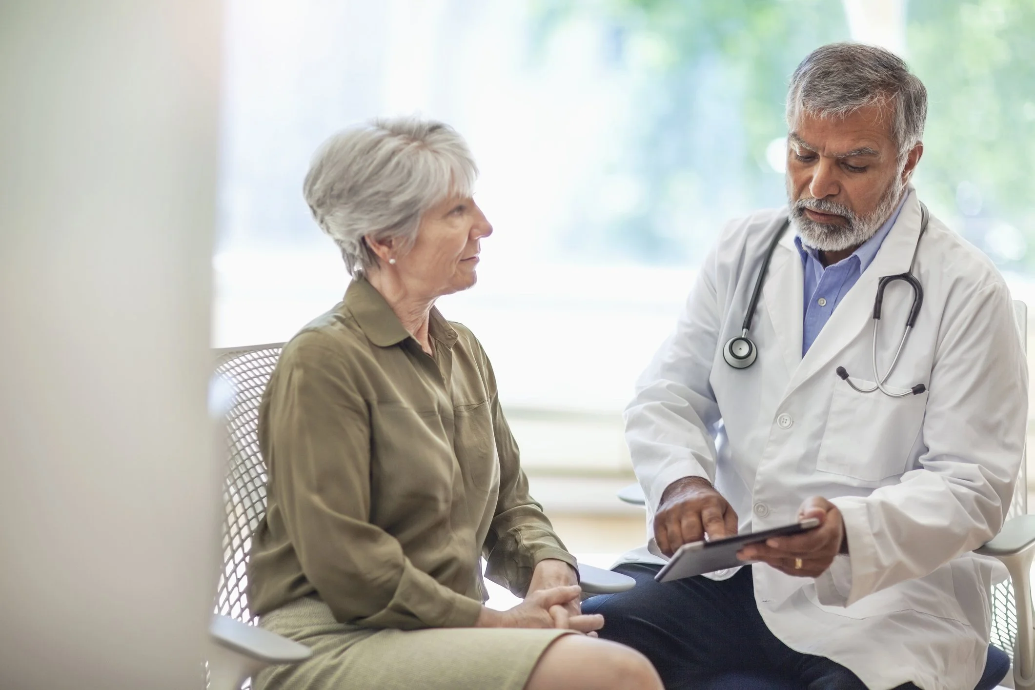 Doctor discussing lung cancer screening and early detection with an older patient during a medical consultation.