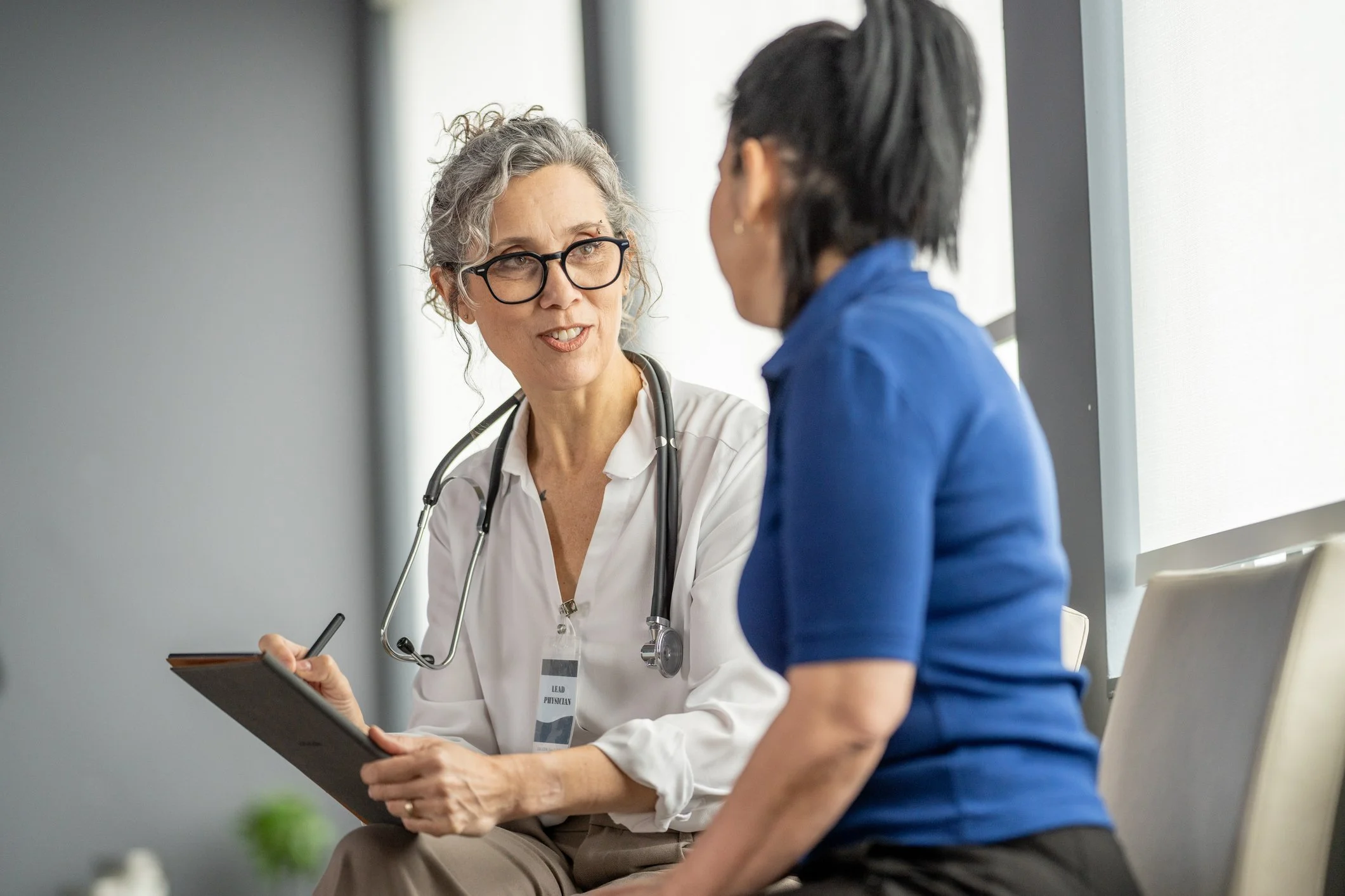 Doctor speaking with a patient about lung cancer risk factors, symptoms, screening, and early detection.