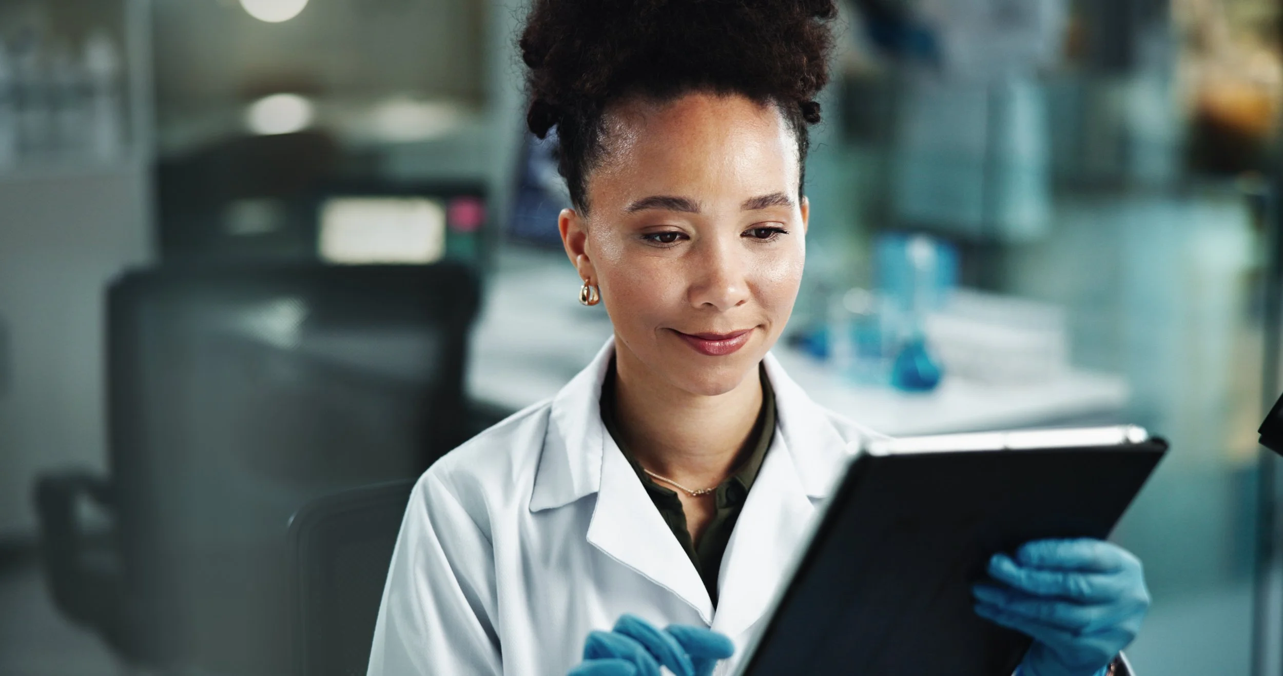 Laboratory scientist reviewing clinical data on a tablet, representing research advances that are improving cancer survival rates.