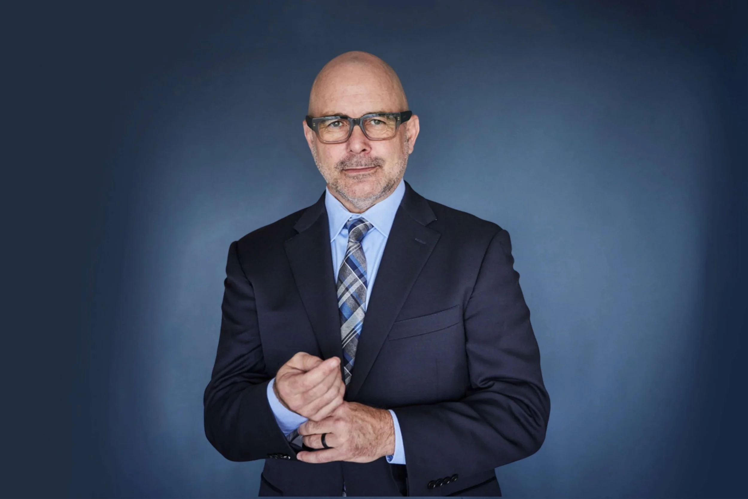 Joe Bellezzo in suite and tie fixing cufflink.