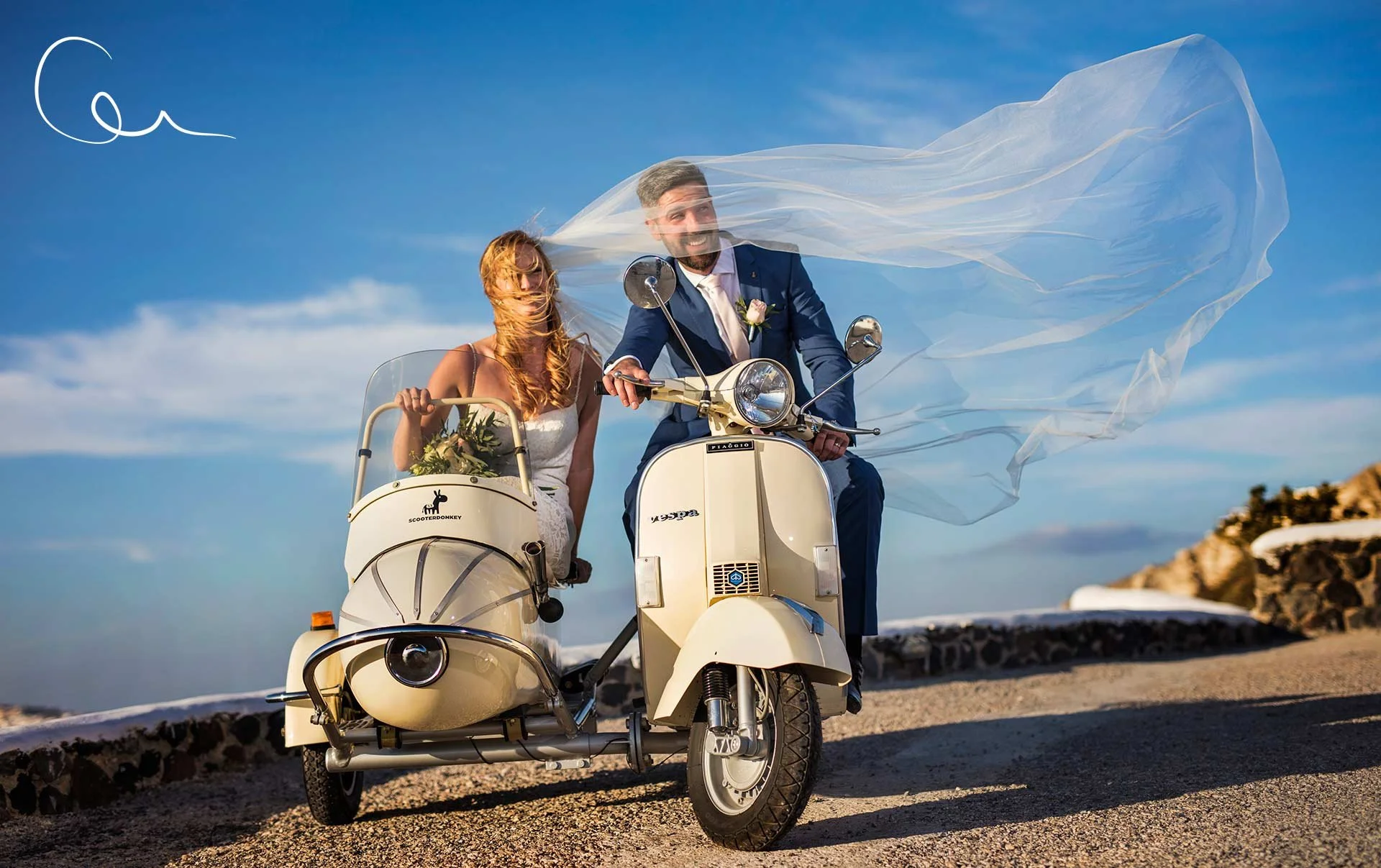 Dramatic drone overhead wedding image of the Santorini caldera with couple on cliff edge, expansive Aegean views and cinematic scale.