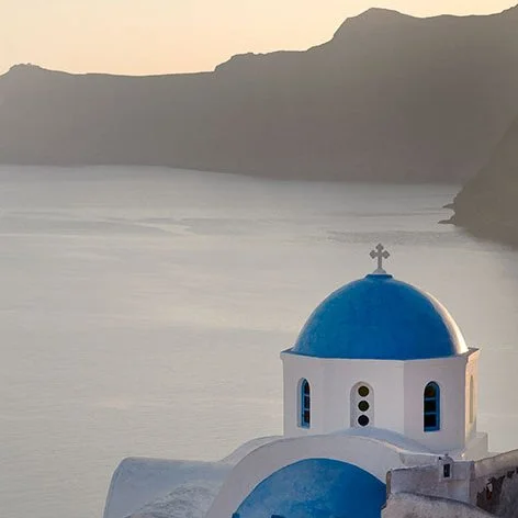 Santorini Red Beach dramatic red volcanic cliffs and pebbled shoreline with sunbathers and turquoise water contrasting volcanic rock.