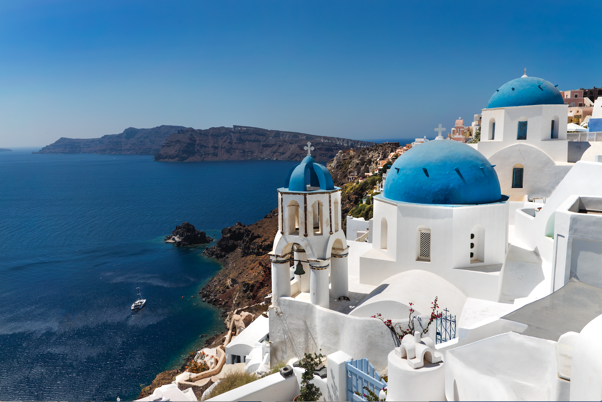Scenic walking trail between Fira and Oia near Imerovigli Santorini with hikers enjoying panoramic caldera views, wind-swept landscape and blue sea.