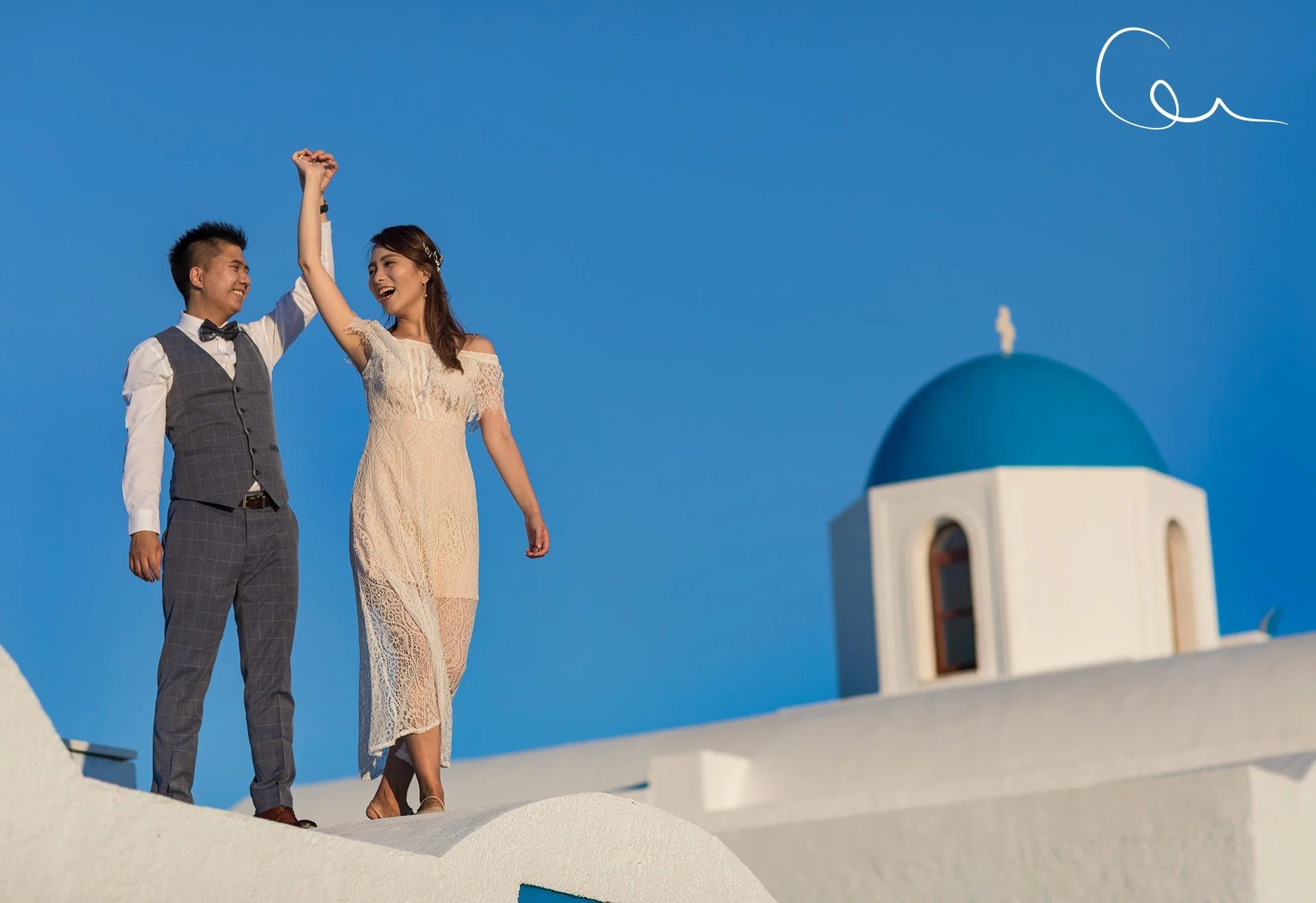 Proposal near fira sea view, with oia sunset hues and blue dome, capturing romantic moment in santorini wedding photography style.