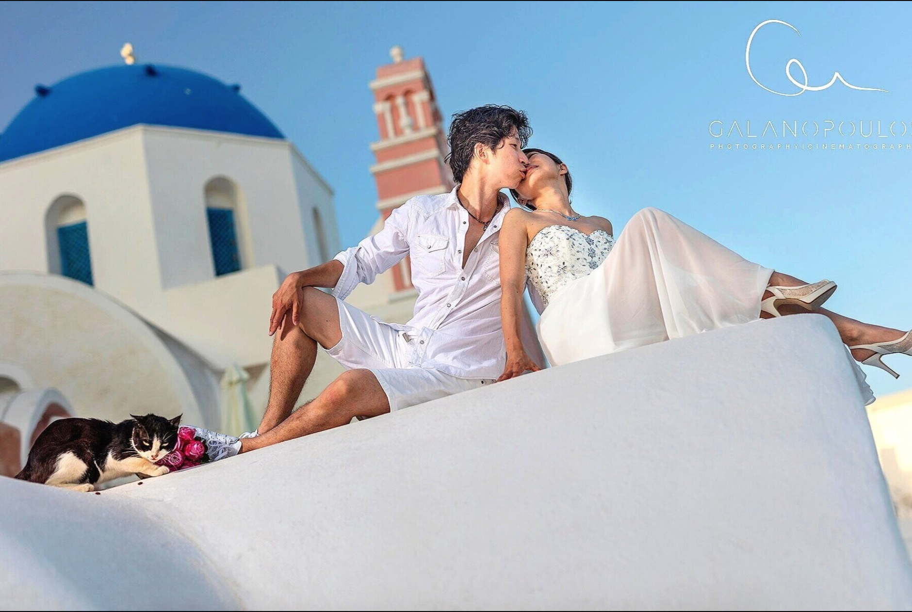 Award-winning Santorini portrait by Galanopoulos of a bride and groom at golden hour on caldera edge capturing intimate emotion and dramatic light.