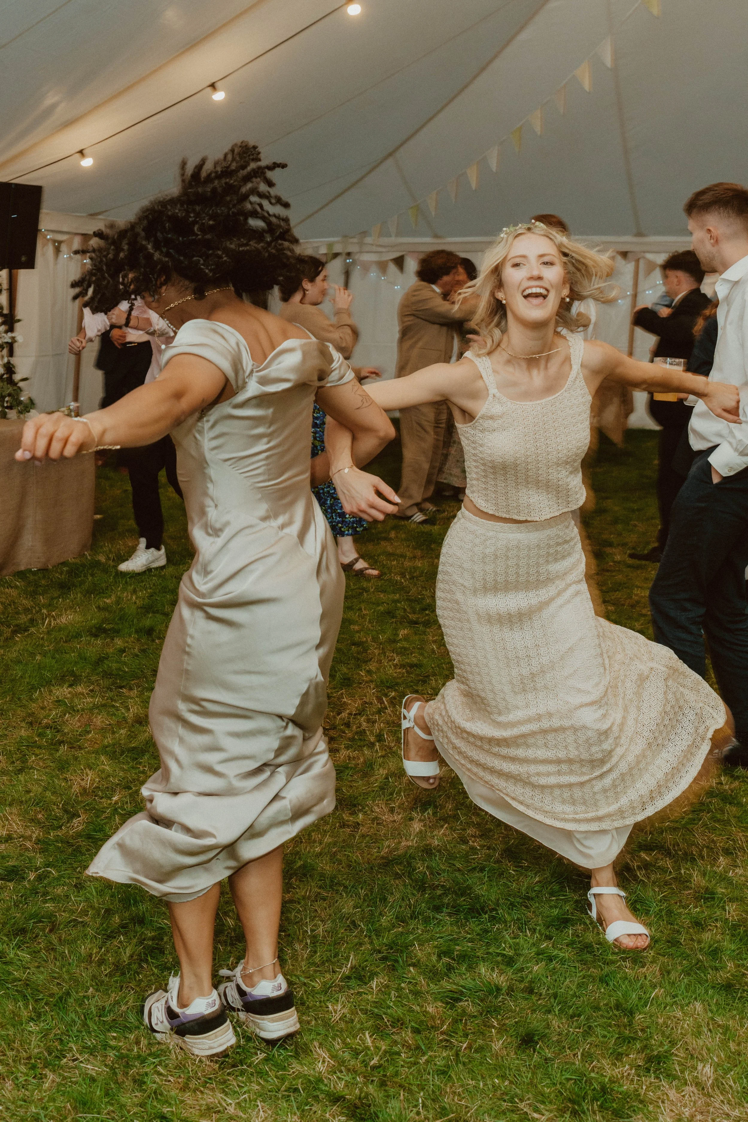 People dancing and enjoying themselves inside a tent at a celebration or party.