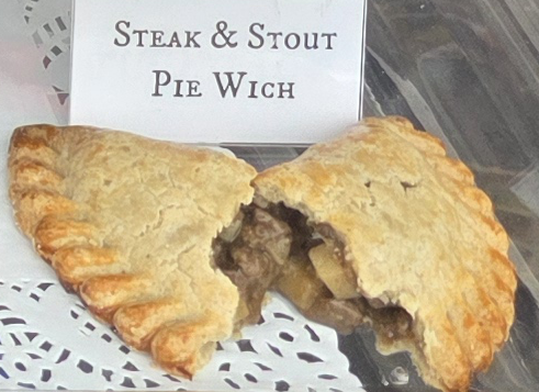 A delicious Pie Wich hand pie opened to show the ingredients, along with a card indicating the flavor.