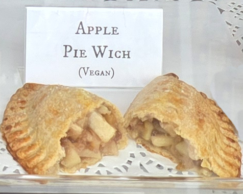 A delicious Pie Wich hand pie opened to show the ingredients, along with a card indicating the flavor.