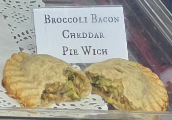 A delicious Pie Wich hand pie opened to show the ingredients, along with a card indicating the flavor.