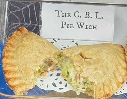 A delicious Pie Wich hand pie opened to show the ingredients, along with a card indicating the flavor.