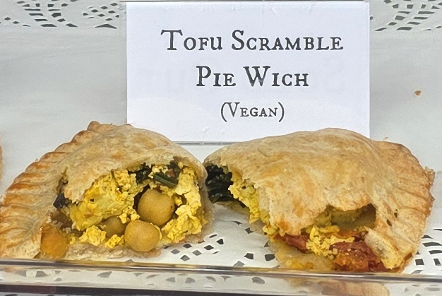 A delicious Pie Wich hand pie opened to show the ingredients, along with a card indicating the flavor.
