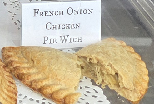 A delicious Pie Wich hand pie opened to show the ingredients, along with a card indicating the flavor.