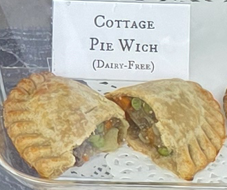 A delicious Pie Wich hand pie opened to show the ingredients, along with a card indicating the flavor.