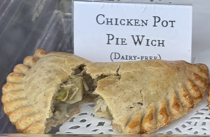 A delicious Pie Wich hand pie opened to show the ingredients, along with a card indicating the flavor.