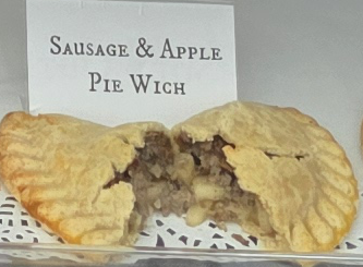 A delicious Pie Wich hand pie opened to show the ingredients, along with a card indicating the flavor.