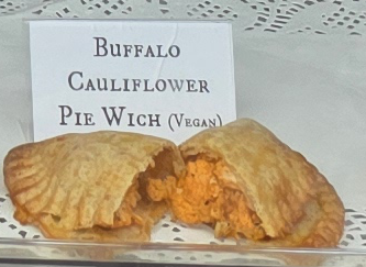 A delicious Pie Wich hand pie opened to show the ingredients, along with a card indicating the flavor.